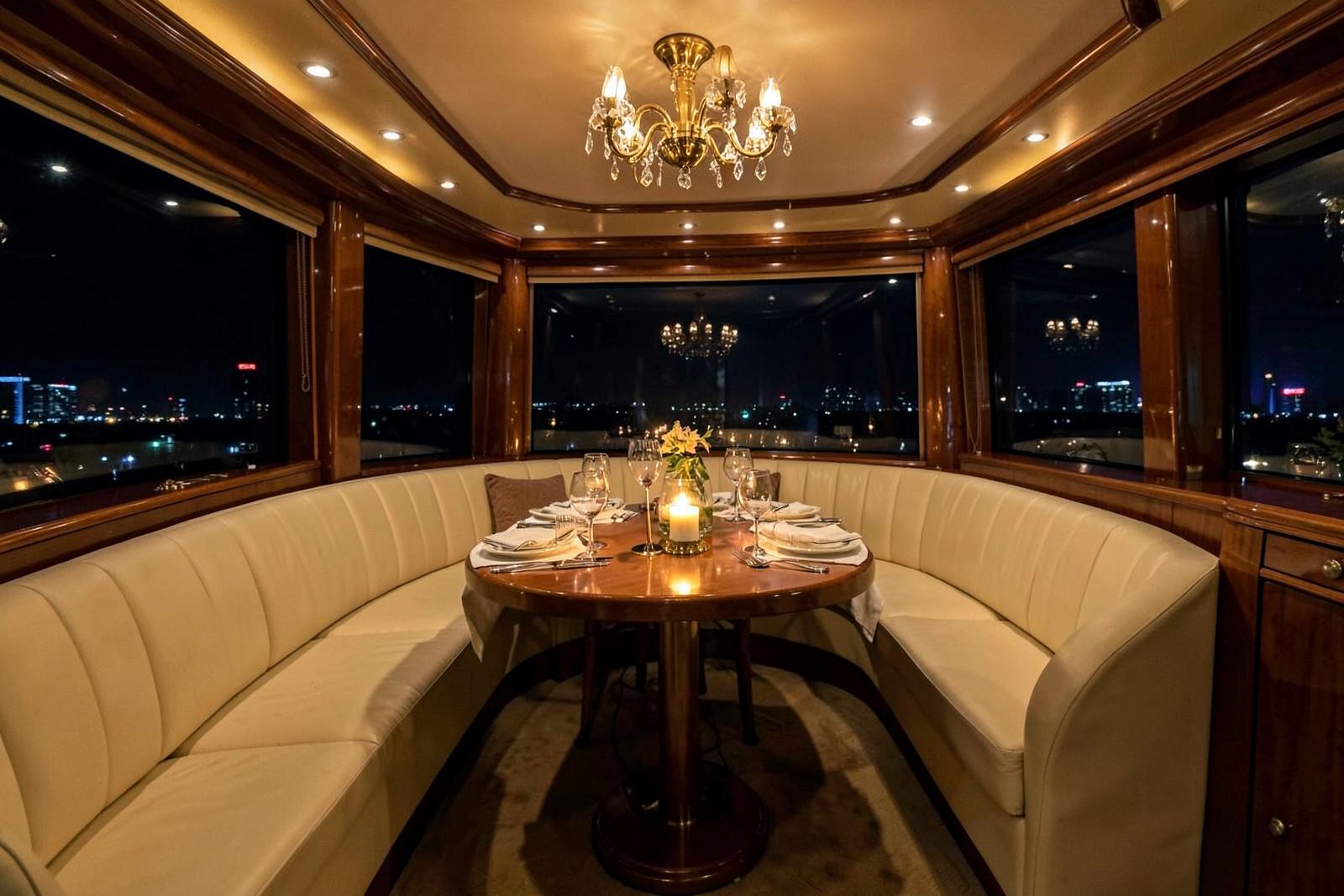 Illustrative scene: a warmly lit private yacht saloon with a round dining table set for a celebration at night.
